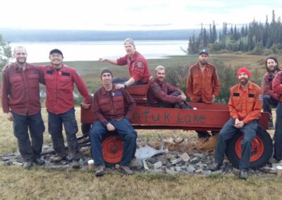 Firefighters posing beside Tatuk Lake sign